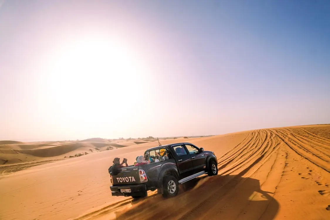 4x4 avec voyageurs dans les dunes de Merzouga